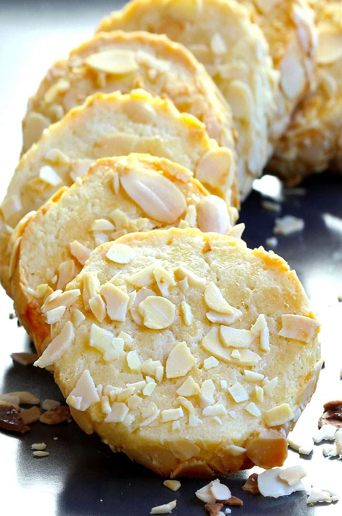 Buttery melt-in-your-mouth sugar cookies with the tang of cream cheese and garnished with slivered almonds.