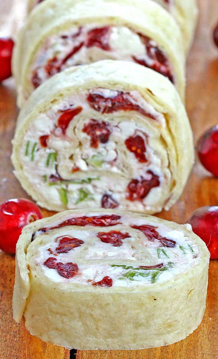 Festive red, green, and white - Cranberry Feta Tortilla Roll Ups are a absolute must make for Christmas or New Year's Eve get together.