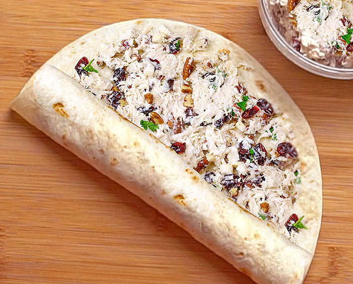 Enjoy easy-to-make Cranberry Pecan Chicken Salad in Tortilla Roll-Ups, Wraps, sandwiches, or straight out of the bowl for a dinner or holiday menu, especially Thanksgiving or Christmas. This is a terrific recipe for using up leftover chicken or turkey