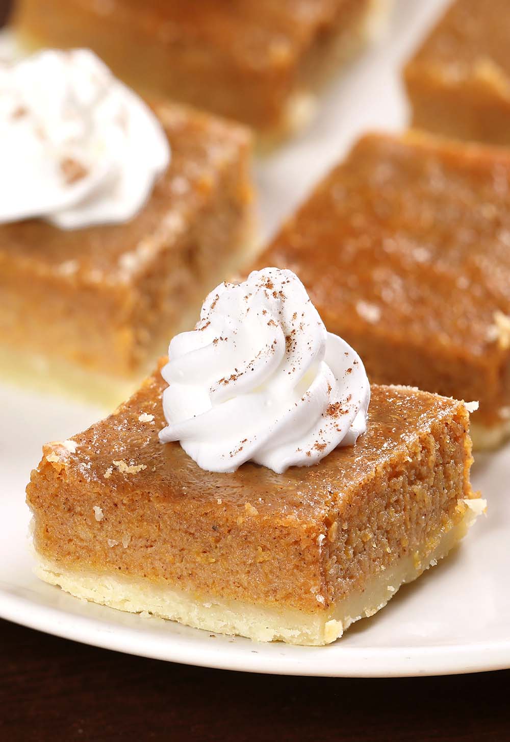Easy Pumpkin Pie Bars are the perfect Thanksgiving or Halloween dessert for a crowd! Creamy homemade pumpkin pie on top of a buttery crust, top it with whipped cream or serve a la mode!