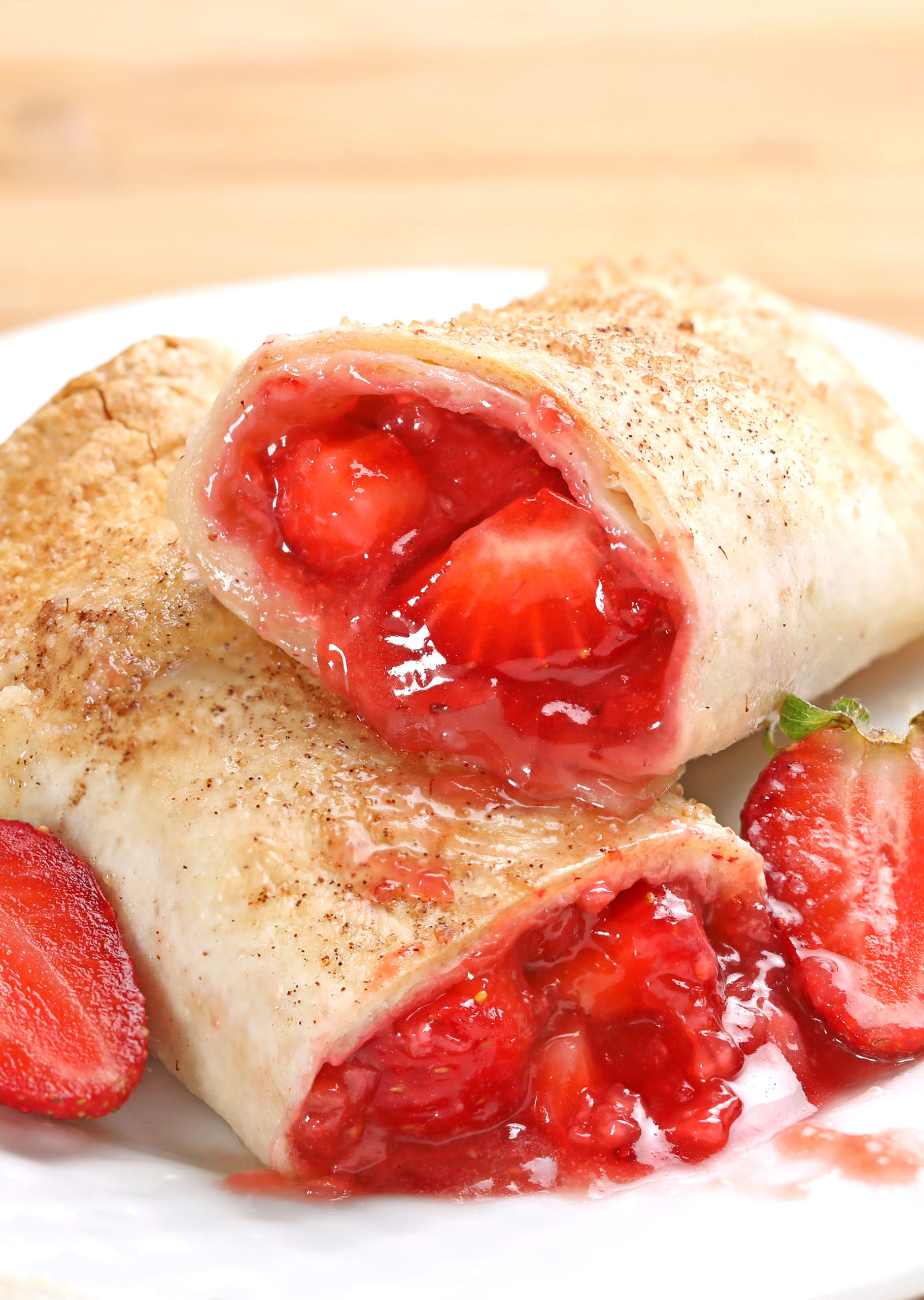 Strawberry Pie Enchiladas - It’s a bubbly, gooey, buttery, and berry miracle! Strawberry Pie filling made with fresh strawberries rolled in tortillas and coated with cinnamon sugar. #strawberry #enchiladas